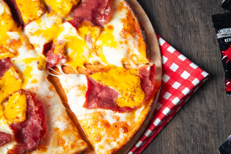 Sauce being drizzled over a fresh pizza